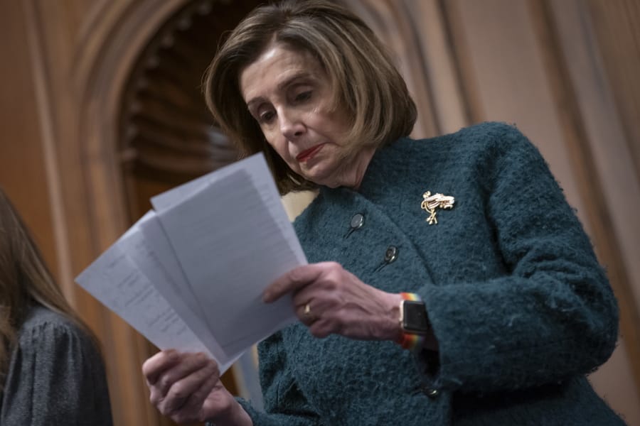 Speaker of the House Nancy Pelosi, D-Calif., reads a note handed to her from an aide as she attends a health care event at the Capitol in Washington, Wednesday, Dec. 11, 2019.  (AP Photo/J.