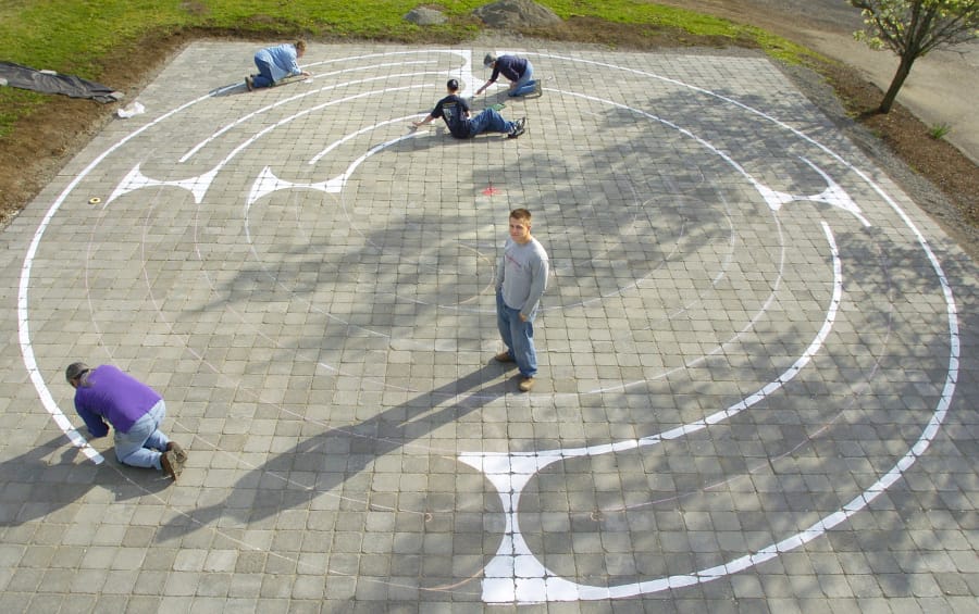 In this file photo from March 2005, Eagle Scout Peter Sterr, center, watches while friends and family paint a labyrinth pattern onto brick pavers at Beautiful Savior Lutheran Church in east Vancouver.