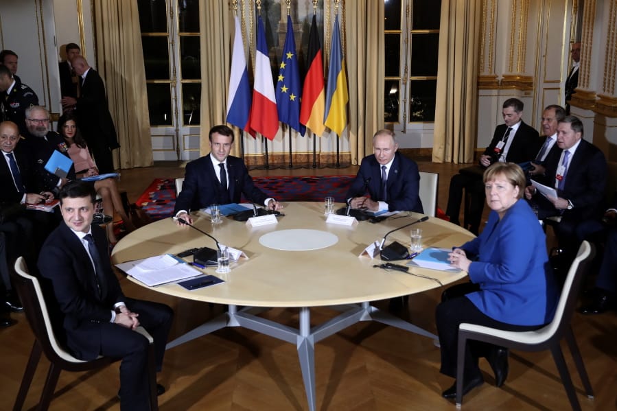 French President Emmanuel Macron, center left, Russian President Vladimir Putin, center right, German Chancellor Angela Merkel and Ukrainian President Volodymyr Zelenskiy, left, attend a working session at the Elysee Palace Monday, Dec. 9, 2019 in Paris. Russian President Vladimir Putin and Ukraine&#039;s president are meeting for the first time at a summit in Paris to find a way to end the five years of fighting in eastern Ukraine.