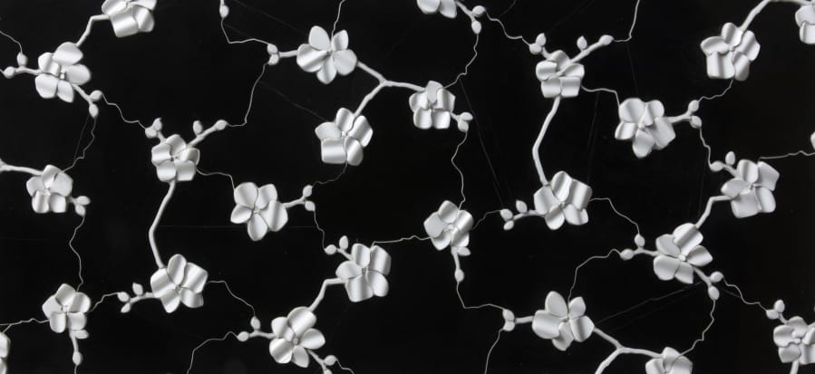 This photo provided by Artistic Tile shows Michael Aram&#039;s orchid design transformed into a striking three dimensional ceramic tile by Artistic Tile. The tile has dozens of hand formed flowers on a black or white background. The pattern is also available in a 2D version for floors and other purposes.
