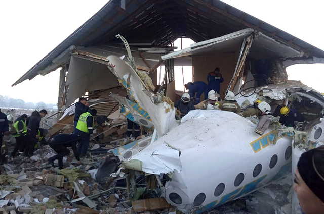 In this handout photo provided by the Emergency Situations Ministry of the Republic of Kazakhstan, police and rescuers work on the side of a plane crash near Almaty International Airport, outside Almaty, Kazakhstan, Friday, Dec. 27, 2019. Almaty International Airport said a Bek Air plane crashed Friday in Kazakhstan shortly after takeoff causing numerous deaths. The aircraft had 100 passengers and crew onboard when hit a concrete fence and a two-story building shortly after takeoff.