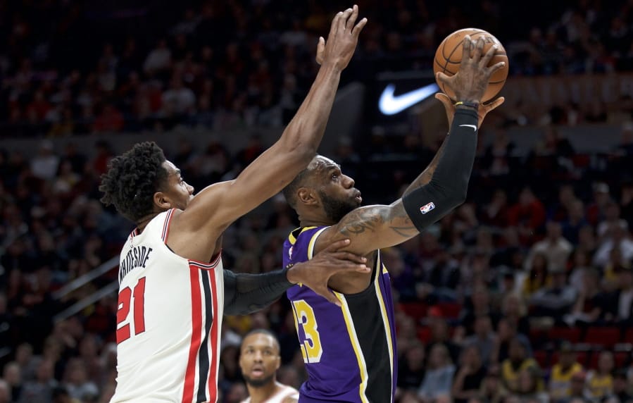 Los Angeles Lakers forward LeBron James, right, shoots in front of Portland Trail Blazers center Hassan Whiteside during the first half of an NBA basketball game in Portland, Ore., Saturday, Dec. 28, 2019.