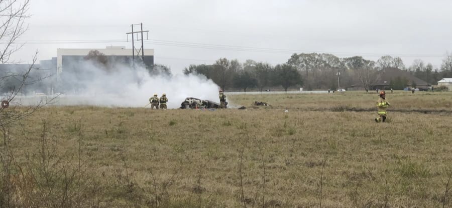 This photo provided by AcadianNews shows first responders looking over the site of a plane crash near Feu Follet Road and Verot School Road in Lafayette, La., Saturday, Dec. 28, 2019.  Authorities confirmed the accident but details on whether anyone was injured was not immediately known.