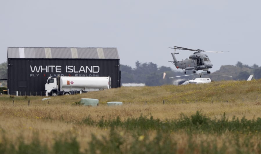 A Navy helicopter hovers at Whakatane Airport, as the recovery operation to return the victims of the Dec. 9 volcano eruption continues off the coast of Whakatane New Zealand, Friday, Dec. 13, 2019. A team of eight New Zealand military specialists landed on White Island early Friday to retrieve the bodies of victims after the Dec. 9 eruption.