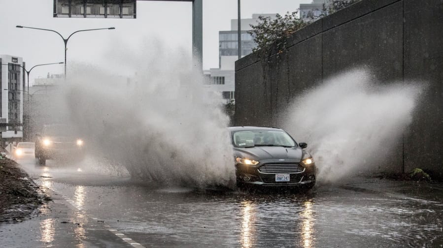 The I-5 northbound onramp from Mercer Street was flooded as cars became boats kicking up a big wake in a rainstorm on Friday, Dec. 20, 2019, in Seattle. A storm that has brought record rainfall to the Northwest has broken some records, prompted flood warnings, disrupted train traffic and caused some power outages.