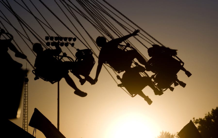 FILE - In this July 23, 2009 file photo, children are silhouetted by the setting sun as they ride a swing ride during the Canyon County Fair in Caldwell, Idaho. New results published Monday, Dec. 9, 2019,  in JAMA Pediatrics from the largest long-term study of brain development and children&#039;s health raise provocative questions about obesity and brain function.