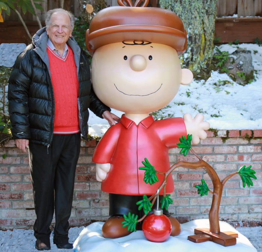 Lee Mendelson stands with a Charlie Brown figure in 2015.