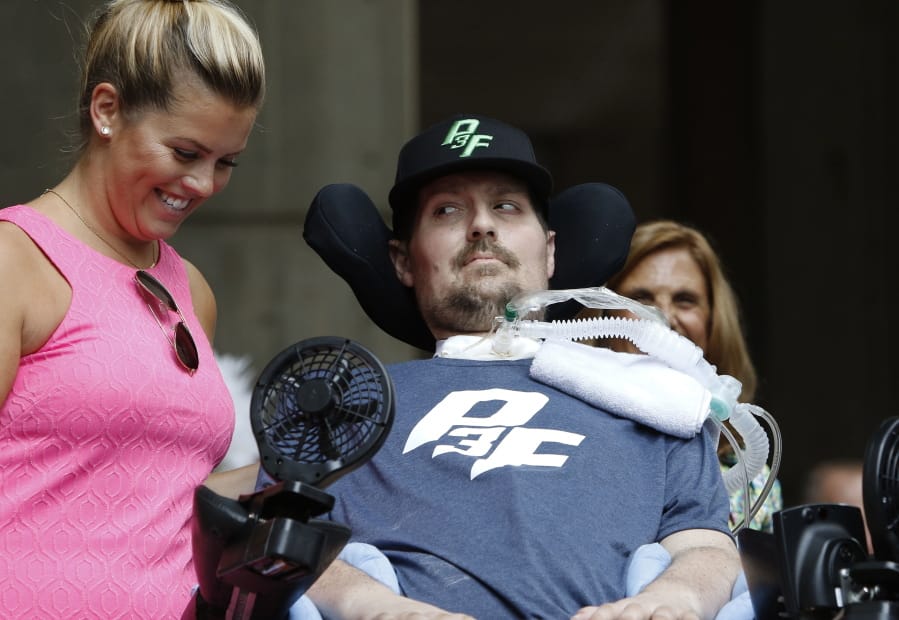 FILE - In this Sept. 5, 2017, file photo, Pete Frates, right, who inspired the ice bucket challenge, looks at his wife Julie during a ceremony at City Hall in Boston by Boston Mayor Marty Walsh declaring the day the Pete Frates Day. Frates, who was stricken with amyotrophic lateral sclerosis, or ALS, died Monday, Dec. 9, 2019. He was 34.