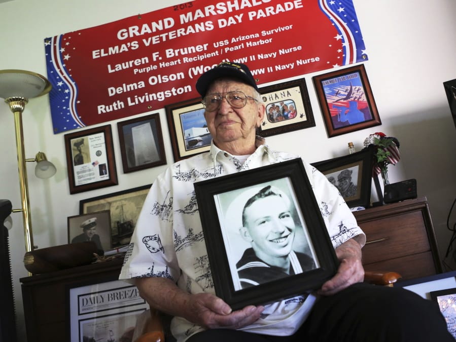 Lauren Bruner, a Pearl Harbor survivor, holds a 1940 photo of himself at his home in La Mirada, Calif, in November 2016. Bruner, who served on the USS Arizona, died in September at the age of 98.