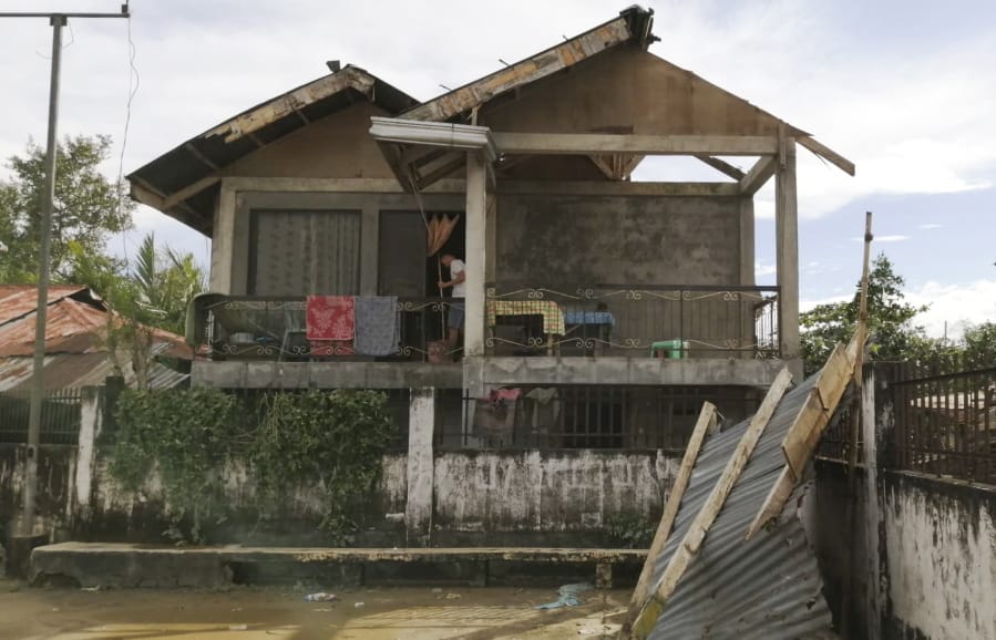 A resident checks his home damaged by Typhoon Phanfone in Ormoc city, central Philippines on Thursday Dec. 26, 2019. The typhoon left over a dozen dead and many homeless.