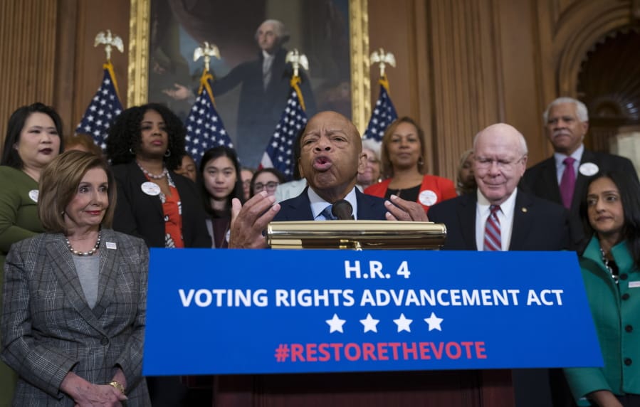 FILE - In this Friday, Dec. 6, 2019, file photo, civil rights leader U.S. Rep. John Lewis, D-Ga., flanked by Speaker of the House Nancy Pelosi, D-Calif., left, and Sen. Patrick Leahy, D-Vt., speaks at an event with House Democrats before passing the Voting Rights Advancement Act to eliminate potential state and local voter suppression laws, at the Capitol in Washington. Lewis announced Sunday, Dec. 29, 2019, that he has stage IV pancreatic cancer, vowing he will stay in office and fight the disease with the tenacity which he fought racial discrimination and other inequalities since the civil rights era. (AP Photo/J.