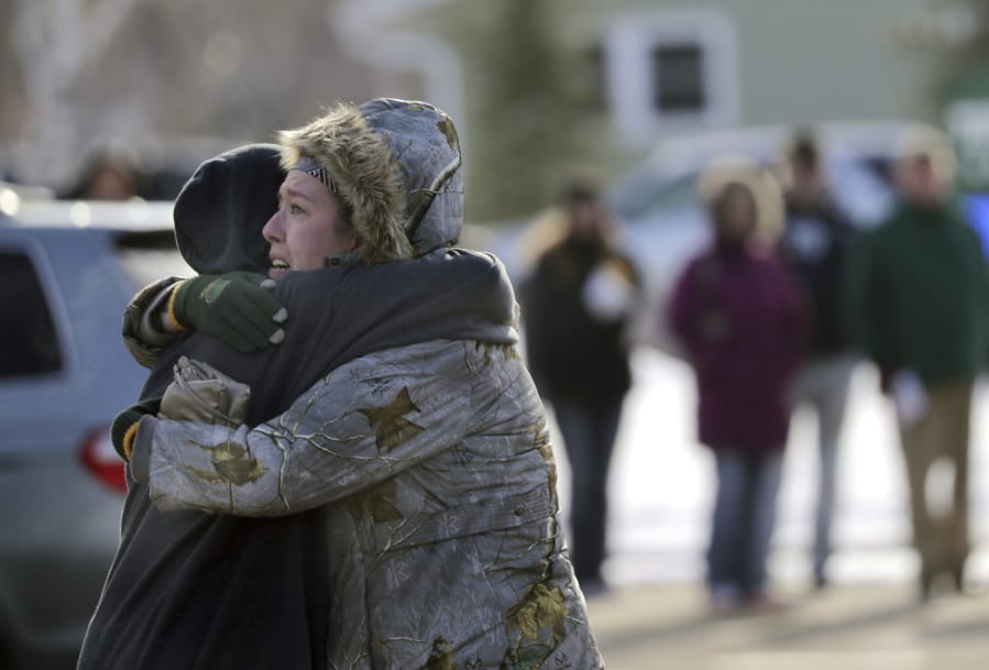 Sarah Rogstad, right, hugs Morgan Rogstad, grade 9, after being reunited at the Tipler Middle school reunification center on Tuesday December 3, 2019, in Oshkosh, Wis. Earlier, police responded to an officer invloved shooting at Oshkosh West High School after an armed student confronted a school resource officer.  (Wm. Glasheen/The Post-Crescent via AP) (wm.