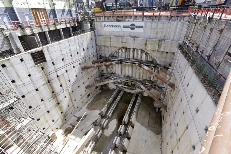 FILE - In this April 3, 2017, file photo, a concrete-walled pit surrounds a circular, five-foot deep concrete wall where a massive tunnel machine was expected to break through the next day as it completes boring for the State Route 99 highway in Seattle. On Friday, Dec. 13, 2019, a jury awarded the Washington State Department of Transportation $57.2 million in damages over delays in the construction of the tunnel.