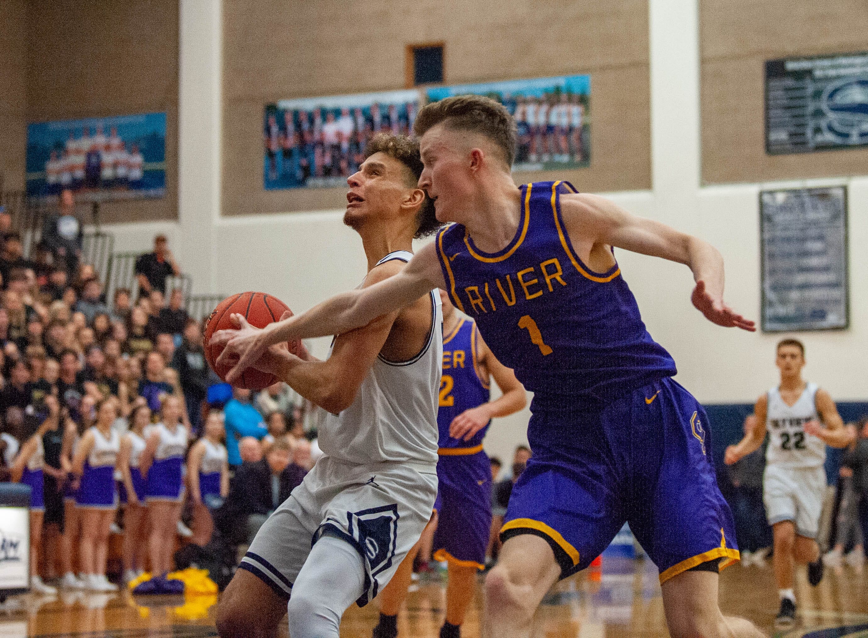 Skyview's Squeeky Johnson tries to evade Columbia River's Nate Snook on a fastbreak layup.