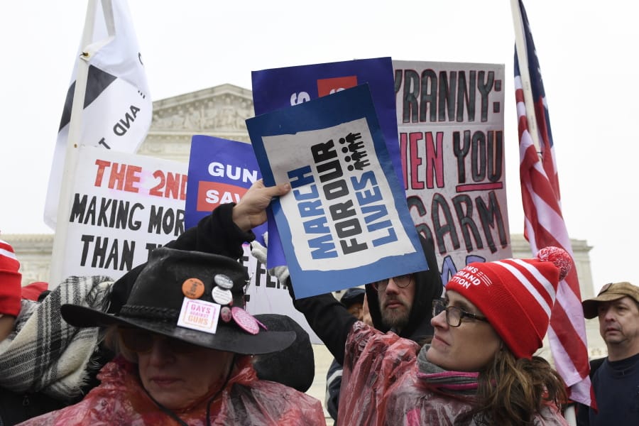Protesters gather outside the Supreme Court in Washington, Monday, Dec. 2, 2019, during arguments in the first gun rights case before the Supreme Court in nine years. The case was filed by three New York City gun owners who are challenging a ban on carrying a licensed handgun outside city limits to a gun range, shooting competition or second home outside city limits.