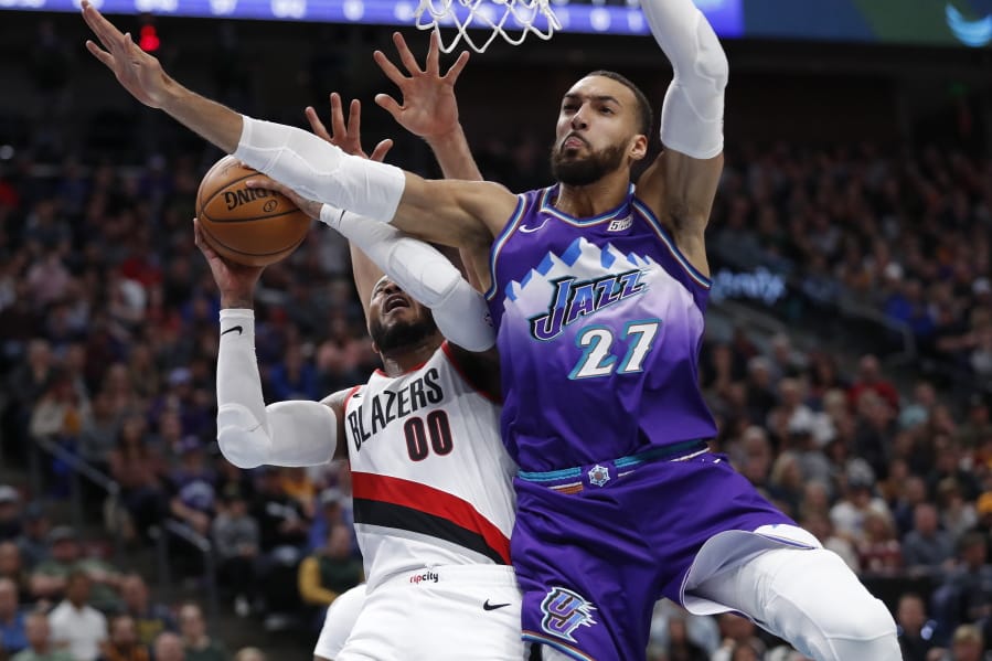 Portland Trail Blazers forward Carmelo Anthony (00) is fouled by Utah Jazz center Rudy Gobert (27) during the second quarter of an NBA basketball game, Thursday, Dec. 26, 2019, in Salt Lake City.