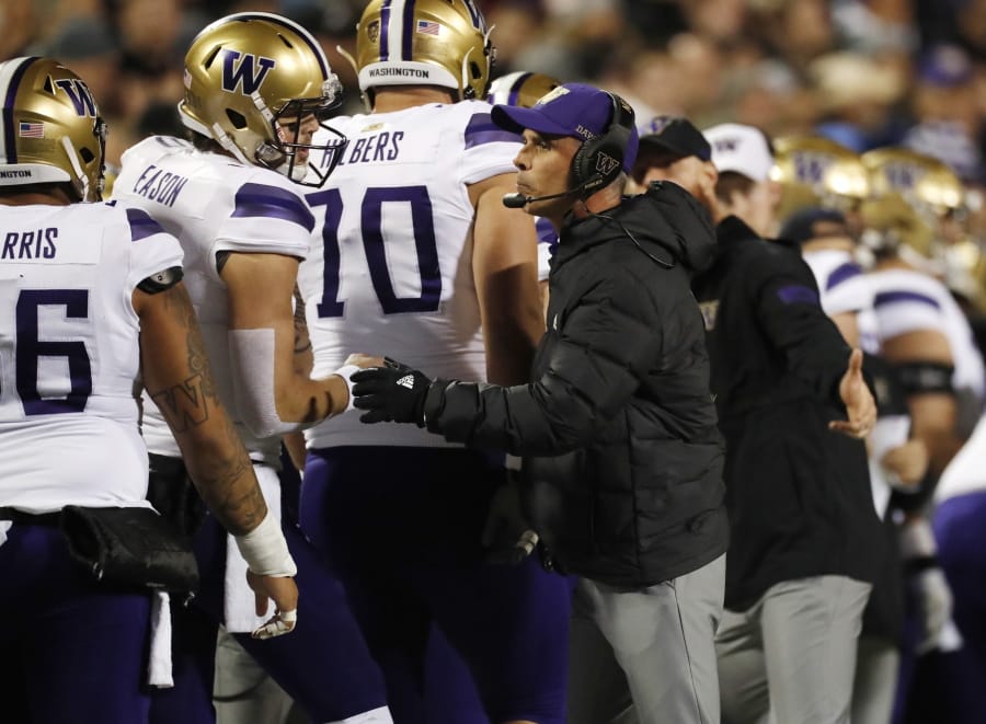 Washington quarterback Jacob Eason, left, confers with coach Chris Petersen during the first half of the team&#039;s NCAA college football game against Colorado on Saturday, Nov. 23, 2019, in Boulder, Colo.