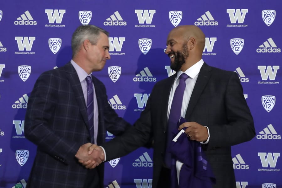 Washington NCAA college football head coach Chris Petersen, left, shakes hands with defensive coordinator Jimmy Lake following a news conference about Lake taking over the head coaching position, Tuesday, Dec. 3, 2019, in Seattle. Petersen unexpectedly resigned on Monday, a shocking announcement with the Huskies coming off a 7-5 regular season and bound for a sixth straight bowl game under his leadership. Petersen will coach Washington in a bowl game, his final game in charge.
