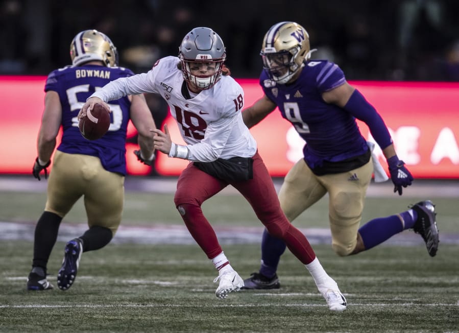 Washington State quarterback Anthony Gordon scrambles out of the pocket as he is chased by Washington linebacker Joe Tryon during the second half of an NCAA college football game, on Friday, Nov. 29, 2019 in Seattle. Washington won 31-13.
