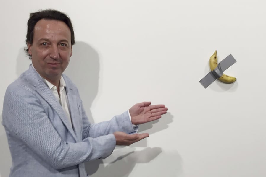 Gallery owner Emmanuel Perrotin poses Dec. 4 next to Italian artist Maurizio Cattlelan&#039;s &quot;Comedian&quot; at the Art Basel exhibition in Miami Beach, Fla. The work sold for $120,000.