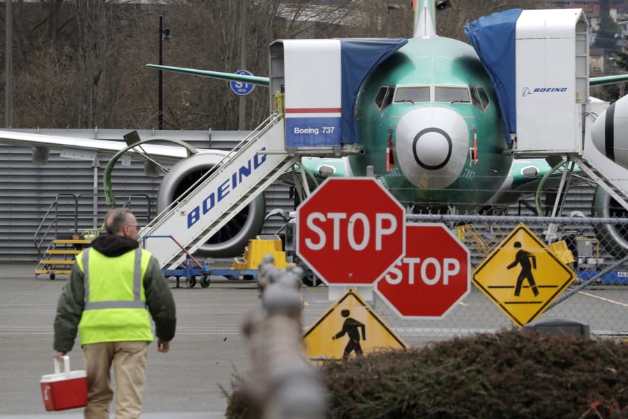 FILE - In this Monday, Dec. 16, 2019, file photo, a Boeing worker walks in view of a 737 MAX jet in Renton, Wash. Boeing announcing the halting of production of its troubled 737 Max airliner was voted Washington state&#039;s top news story of 2019 by Associated Press staff.