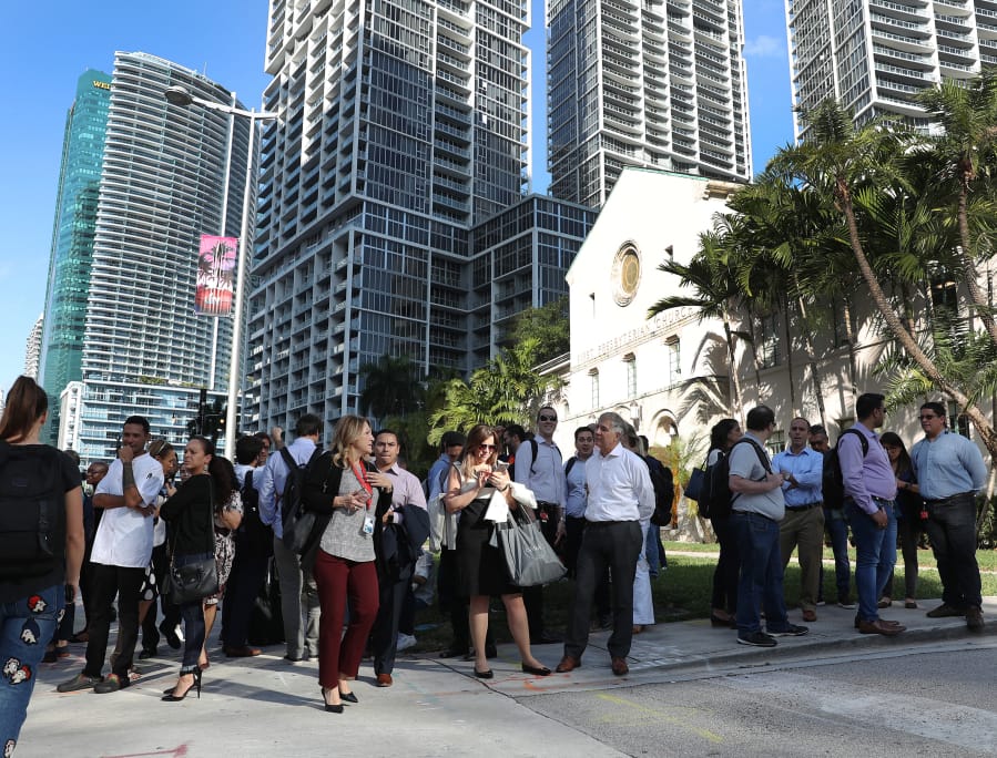People wait outside after evacuating office buildings after an earthquake struck south of Cuba on January 28, 2020 in Miami, Fla.