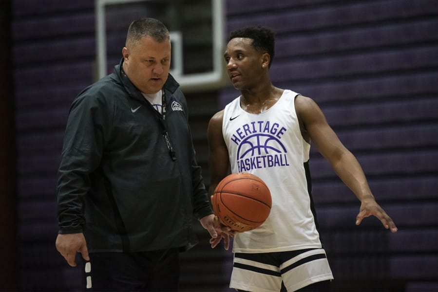 Heritage head coach Brian Childs listens as point guard Capone Johnson asks about a play during a practice Jan. 13 at Heritage High School.