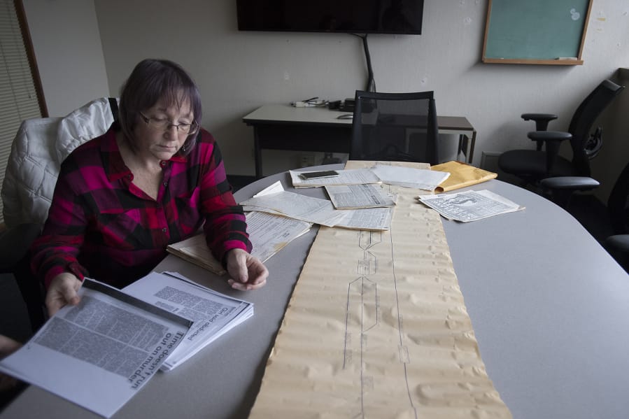 Norma Countryman looks over documents related to Warren Forrest's 1974 murder of Krista Blake at The Columbian on Jan. 10. On the table is a timeline used in the trial.