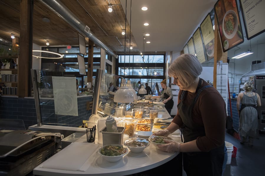 Server Amber Bresler fills orders for customers while working at The Mighty Bowl in downtown Vancouver on Wednesday. Bresler was one of the employees that received a minimum-wage increase on Jan. 1.