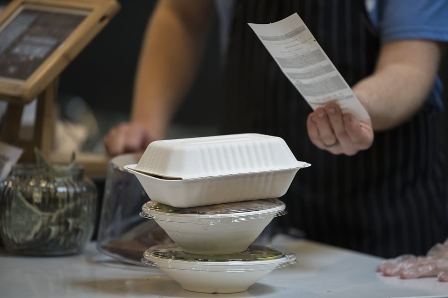 Workers arrange to-go meals in biodegradable take-out boxes and containers at The Mighty Bowl. The popular downtown Vancouver eatery is stopping its use of single-use plastic items and will only use recyclable or compostable items.