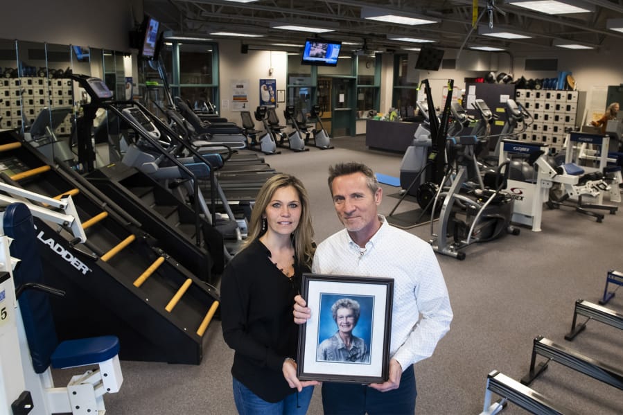 Brad and Nancy Thompson pose with a photo of Gaydena Thompson in the Thompson Fitness Center at Clark College on Friday afternoon. Gaydena Thompson, who died on Dec. 31, 2019, was the first female athletic director at a Washington community college. &quot;I was very proud of everything she accomplished in her life,&quot; Brad Thompson said.