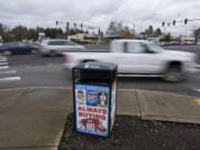 Motorists travel past a receptacle for garbage and recycling with advertisements at the corner of Southeast Chkalov Drive and Southeast Mill Plain Boulevard on Friday morning.
