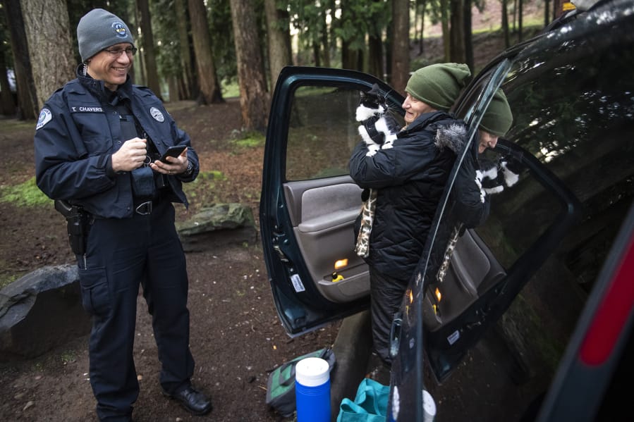 Tyler Chavers, Vancouver&#039;s Homeless Assistance Response Team officer, left, talks with Karalee Grunwald and her cat, Chyzeball, during the 2020 Point in Time count in Vancouver&#039;s Leverich Park. Grunwald said she&#039;s been homeless since June and was recently cited for unlawful camping.