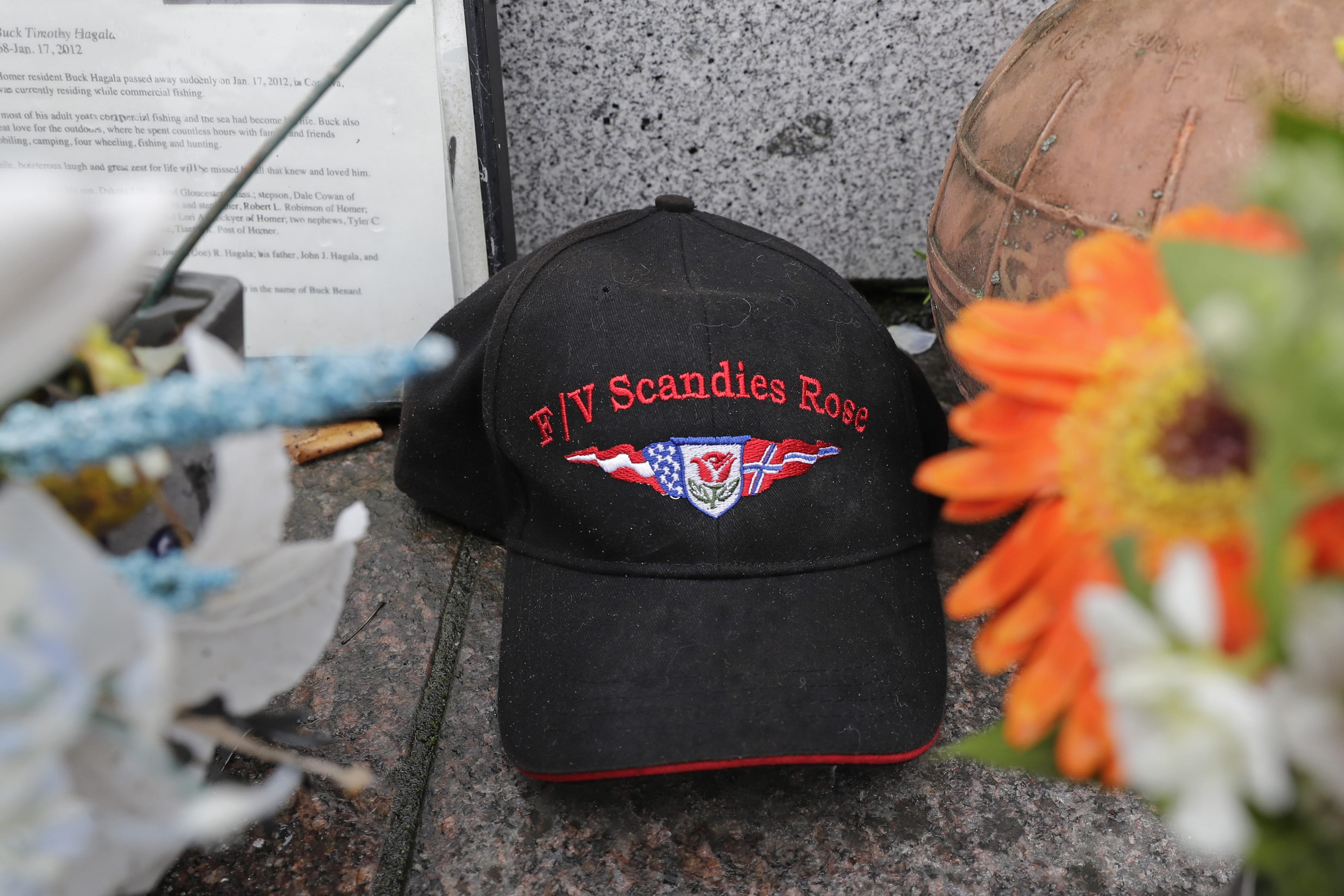 A ball cap with the name of the crab fishing boat Scandies Rose rests at the Seattle Fishermen's Memorial, Thursday, Jan. 2, 2020, in Seattle. The search for five crew members of the Scandies Rose in Alaska has been suspended, the U.S. Coast Guard said after two other crew members of the vessel were rescued after the 130-foot crab fishing boat from Dutch Harbor, Alaska, sank on New Year's Eve. (AP Photo/Ted S.