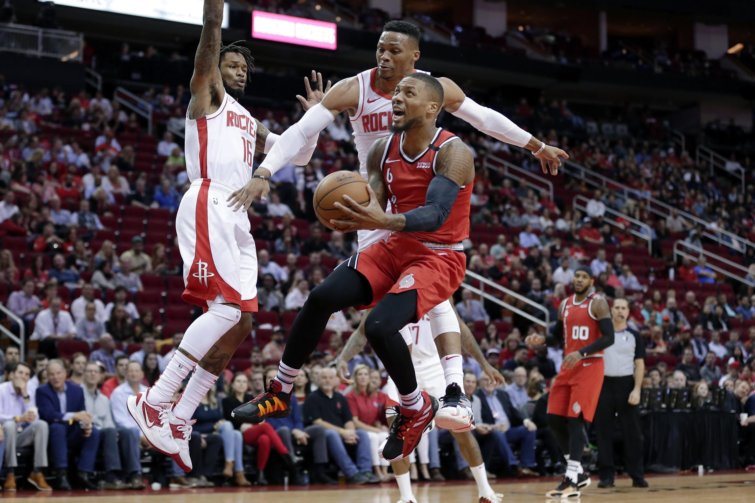 Portland Trail Blazers guard Damian Lillard, middle, puts up a shot in front of Houston Rockets guard Ben McLemore (16) and guard Russell Westbrook, back, as forward Carmelo Anthony (00) looks on during the first half of an NBA basketball game Wednesday, Jan. 15, 2020, in Houston.