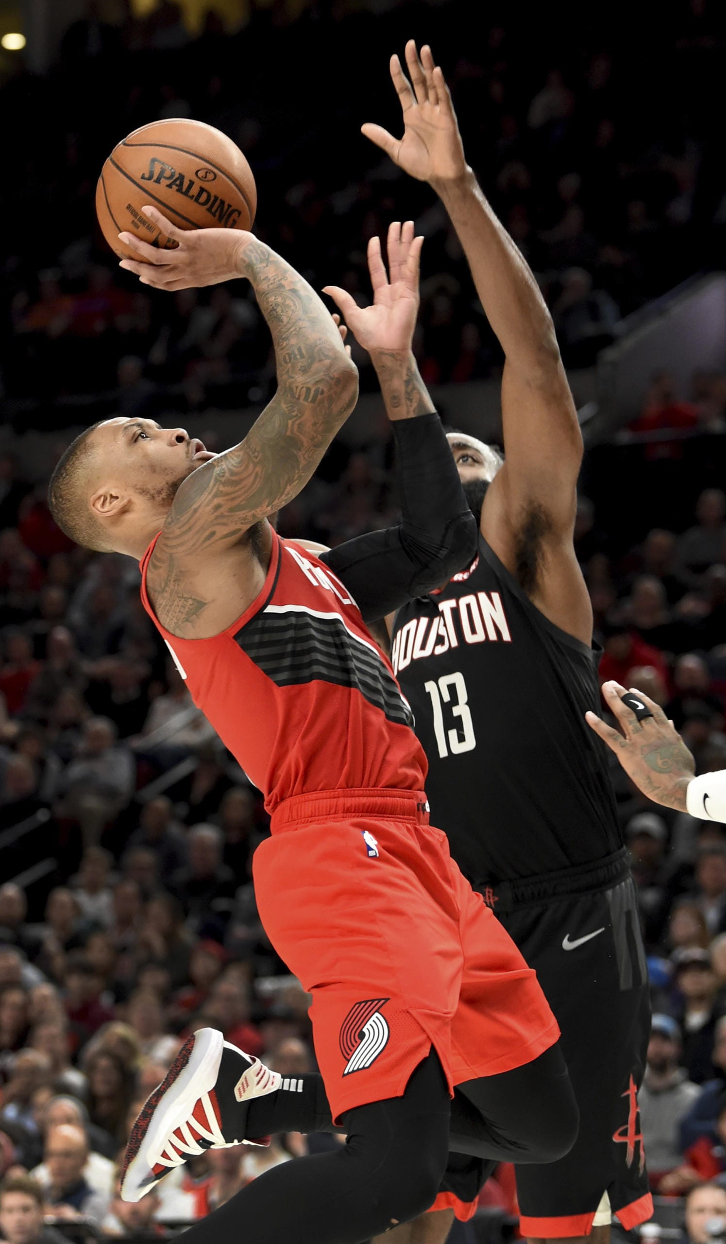 Portland Trail Blazers guard Damian Lillard, left, drives to the basket as Houston Rockets guard James Harden defends during the second half of an NBA basketball game in Portland, Ore., Wednesday, Jan. 29, 2020. The Blazers won 125-112.