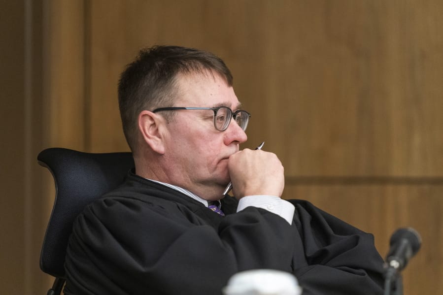 Superior Court Judge Eric Aarseth listens to arguments over an effort to recall Alaska Gov. Mike Dunleavy Friday, Jan. 10, 2020, in Anchorage, Alaska. Judge Aarseth ruled that an effort to recall Republican Gov. Mike Dunleavy may proceed, a decision that is expected to be appealed. The decision followed arguments in the case and came two months after Gail Fenumiai, director of the state Division of Elections, rejected a bid to advance the recall effort.
