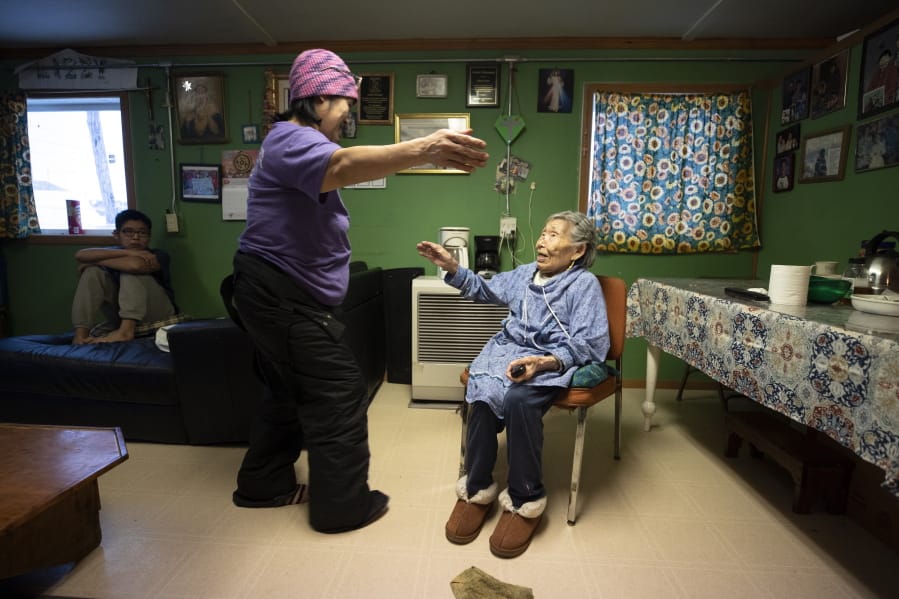 In this Monday, Jan. 20, 2020 image, Lizzie Chimiugak, right, gets a hug from her granddaughter Janet Lawrence at her home in Toksook Bay, Alaska. Chimiugak, who turned 90 years old on Monday, is scheduled to be the first person counted in the 2020 U.S. Census on Tuesday.