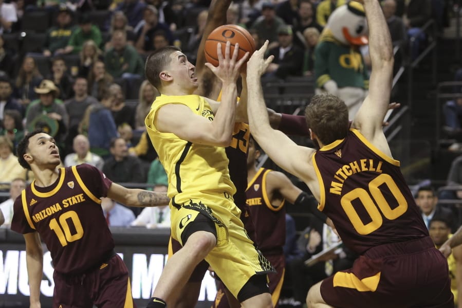 Oregon&#039;s Payton Pritchard, center, is fouled while going to the basket between Arizona State&#039;s Jaelen House, left, and Mickey Mitchell, right, during the second half of an NCAA college basketball game in Eugene, Ore., Saturday, Jan. 11, 2020.