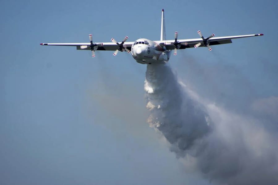 In this undated photo released from the Rural Fire Service, a C-130 Hercules plane called &quot;Thor&quot; drops water during a flight in Australia. Officials in Australia on Thursday, Jan. 23, 2020, searched for a water tanker plane feared to have crashed while fighting wildfires.