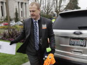 FILE - In this Jan. 13, 2020, file photo, initiative activist Tim Eyman, who is also running as an independent for Washington governor, carries a clipboard as he walks next to his expired car registration tabs before attending a rally on the first day of the 2020 session of the Washington legislature, at the Capitol in Olympia, Wash. Washington Attorney General Bob Ferguson is challenging the lavish personal spending of bankrupt anti-tax activist and candidate for governor Eyman. Ferguson says Eyman&#039;s assets must be preserved so he can pay his debts to the state. The Seattle Times reports that Eyman&#039;s bankruptcy filings show he&#039;s been spending nearly $24,000 a month over the past year. (AP Photo/Ted S.