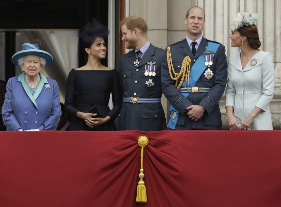 Britain&#039;s Queen Elizabeth II, and from left, Meghan the Duchess of Sussex, Prince Harry, Prince William and Kate the Duchess of Cambridge watch July 10, 2018, a flypast of Royal Air Force aircraft pass over Buckingham Palace in London.