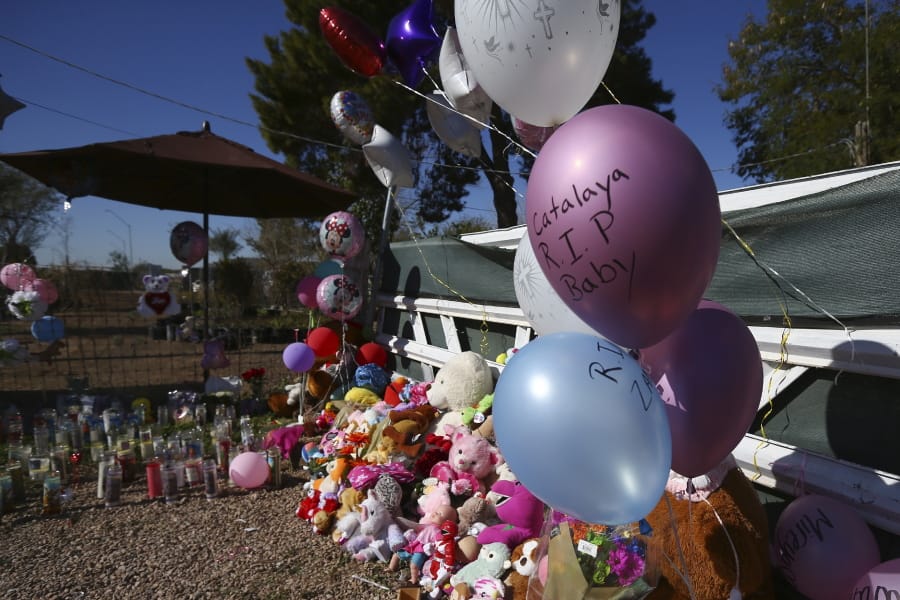 A makeshift memorial grows in front of the home where Rachel Henry was arrested on suspicion of killing her three children after they were found dead inside the family home earlier in the week, shown here Thursday, Jan. 23, 2020, in Phoenix. (AP Photo/Ross D.