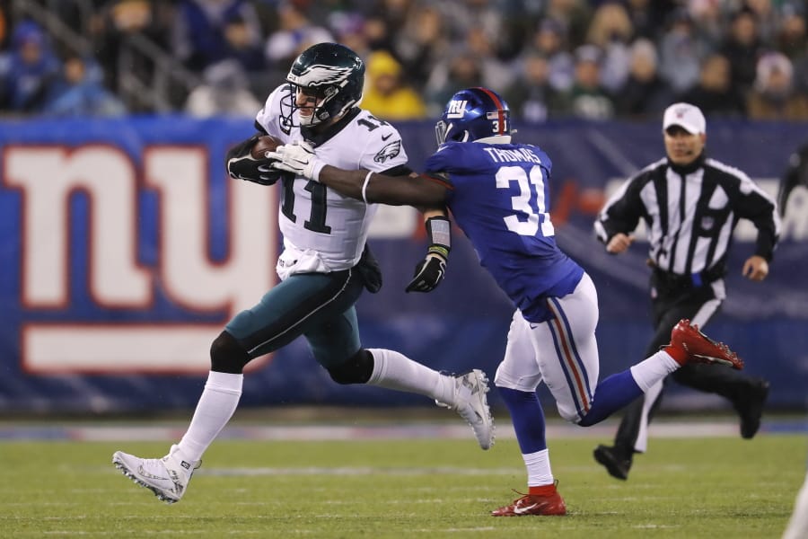 Philadelphia Eagles quarterback Carson Wentz (11) runs with the ball past New York Giants defensive back Michael Thomas (31) in the first half of an NFL football game, Sunday, Dec. 29, 2019, in East Rutherford, N.J.