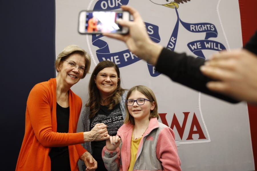 Democratic presidential candidate Sen. Elizabeth Warren, D-Mass., left, poses for a photo with attendees after speaking at a campaign event, Sunday, Jan. 12, 2020, in Marshalltown, Iowa.
