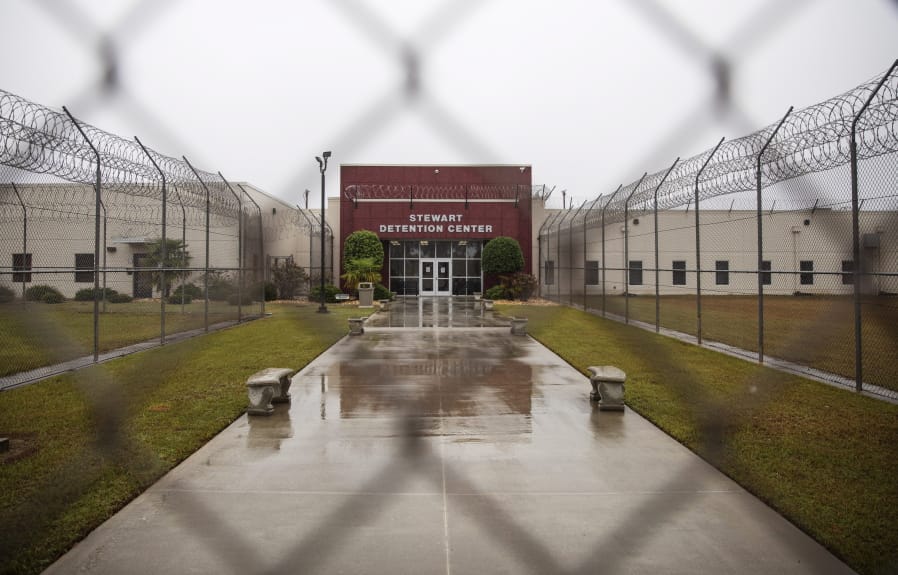 The Stewart Detention Center is seen through the front gate, Friday, Nov. 15, 2019, in Lumpkin, Ga. The rural town is about 140 miles southwest of Atlanta and next to the Georgia-Alabama state line. The town&#039;s 1,172 residents are outnumbered by the roughly 1,650 male detainees that U.S. Immigration and Customs Enforcement said were being held in the detention center in late November.