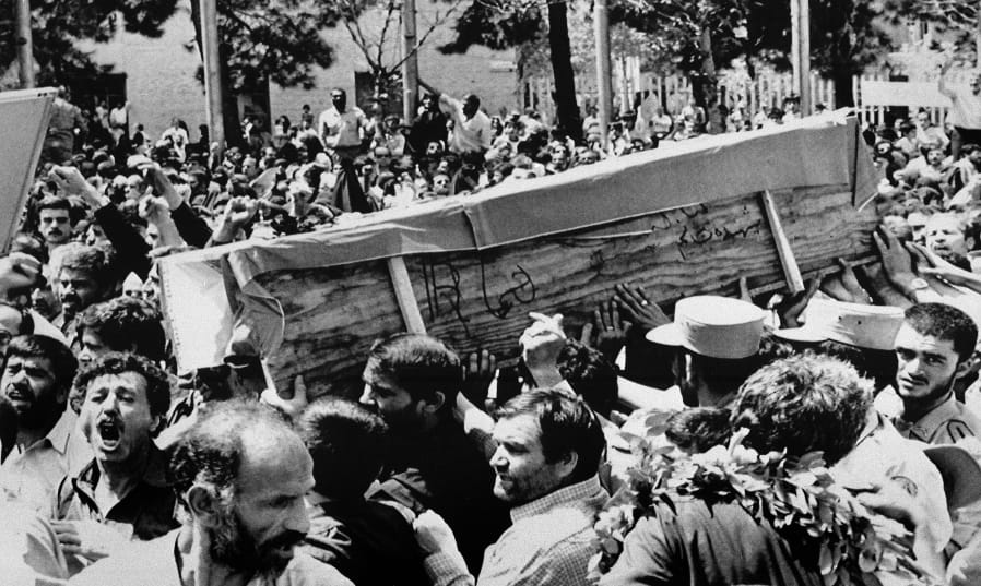 FILE - In this July 7, 1988 file photo, Iranian mourners carry one of 72 caskets to the Cemetery of Martyrs after attending a &quot;Death to America&quot; rally outside the Majlis, or Iranian parliament, in Tehran, Iran. The Western allegation that Iran shot down a Ukrainian jetliner and killed 176 people offers a grim echo for the Islamic Republic, which found itself the victim of an accidental shootdown by American forces over 30 years ago.