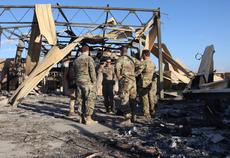 U.S. soldiers stand Jan. 13 at the spot hit by Iranian bombs at Ain al-Asad air base, in Anbar, Iraq. Two Washington-based journalists got an up-close look at the risks faced by American troops in Iraq.