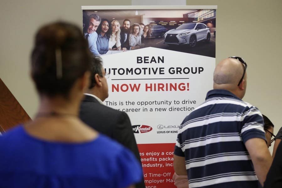 FILE - In this Sept. 18, 2019, file photo people stand in line to inquire about jobs available at the Bean Automotive Group during a job fair in Miami. On Friday, Jan. 10, 2020, the U.S. government issues the December jobs report.
