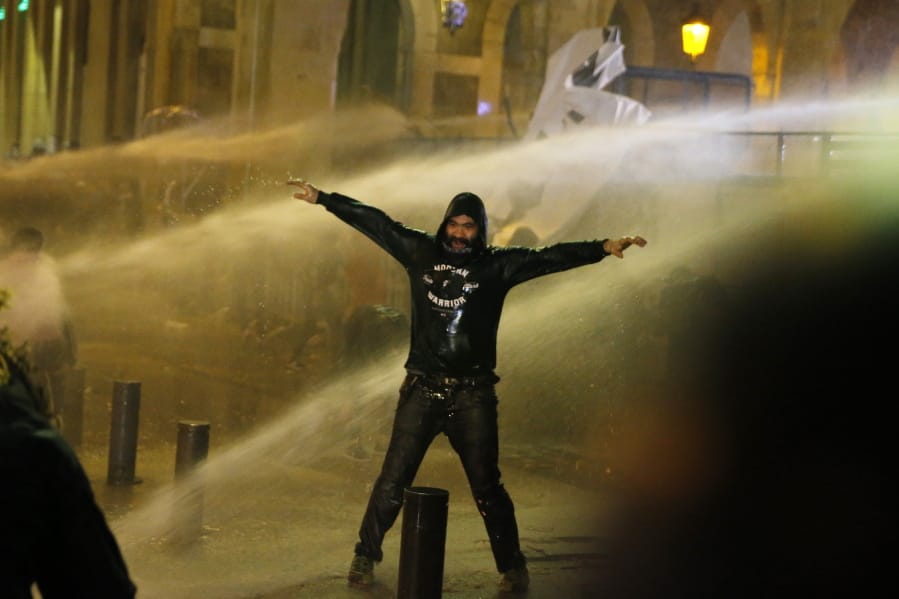 Anti-government protesters are sprayed by a water cannon as they clash with the riot police during ongoing protests in Beirut, Lebanon, Wednesday, Jan. 22, 2020.  Lebanon&#039;s new government has held its first meeting a day after it was formed following a three-month political vacuum.
